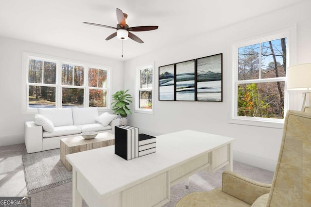 carpeted office space with baseboards, a ceiling fan, and a wealth of natural light
