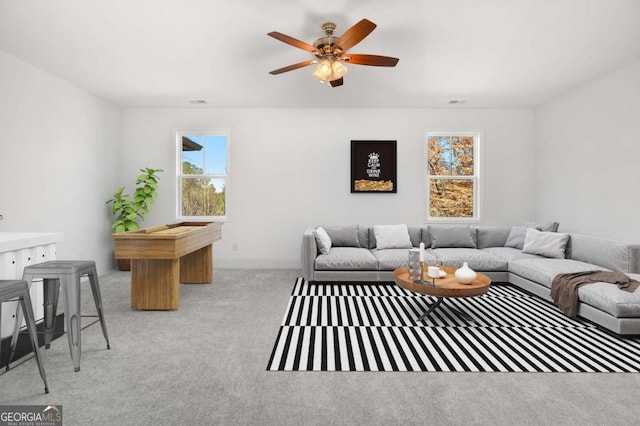 living room with a ceiling fan and carpet