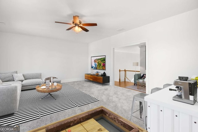 carpeted living room featuring baseboards and ceiling fan