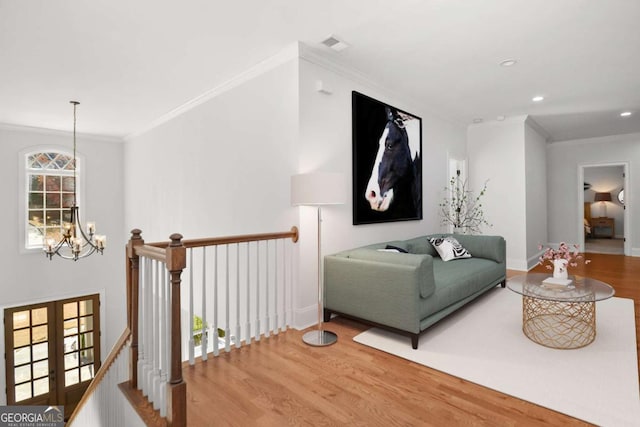 interior space with a chandelier, ornamental molding, and wood finished floors
