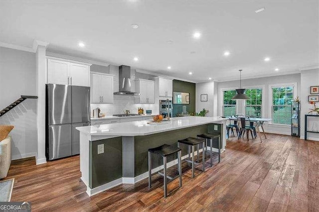 2066 Patterson Park Rd, Decatur, GA 30033 - kitchen featuring wall chimney range hood, appliances with stainless steel finishes, crown molding, and dark wood-style flooring