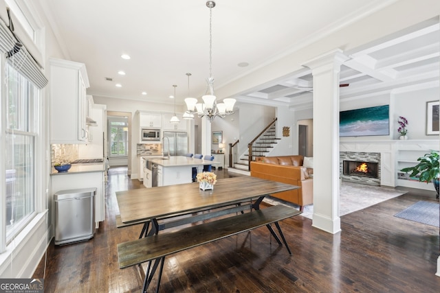 dining room featuring crown molding, a notable chandelier, recessed lighting, a high end fireplace, and dark wood-style floors