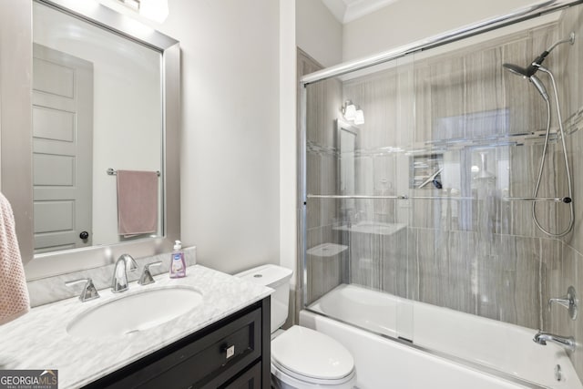 full bath with vanity, bath / shower combo with glass door, and toilet