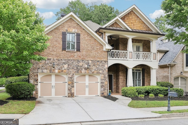view of front facade featuring a standing seam roof, a garage, brick siding, a balcony, and concrete driveway