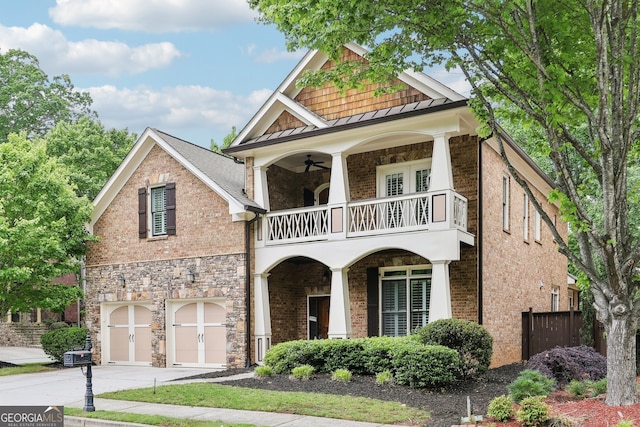 view of front facade with a standing seam roof, fence, a balcony, concrete driveway, and an attached garage