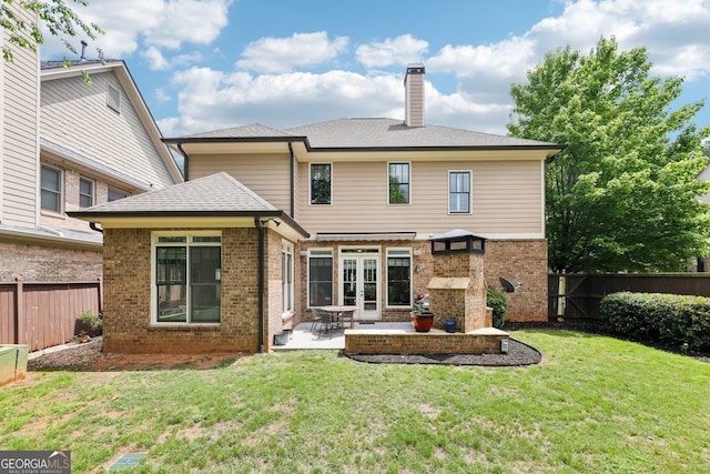 rear view of house with brick siding, a patio, a chimney, and a fenced backyard