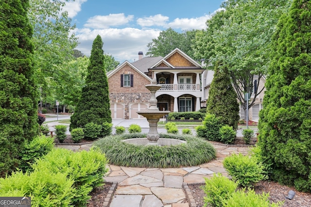 view of front of house with concrete driveway, a balcony, stone siding, and a garage
