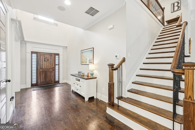 foyer featuring stairs, dark wood-style flooring, baseboards, and visible vents