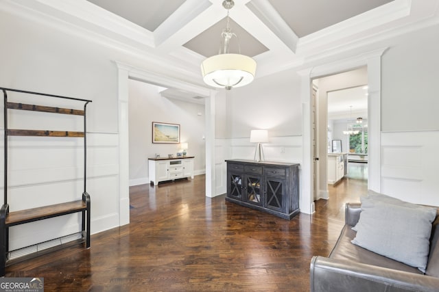 living area featuring wood finished floors, coffered ceiling, a decorative wall, and beam ceiling