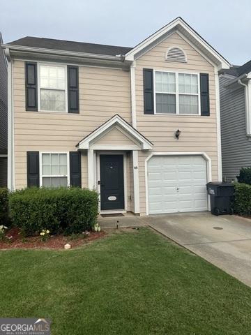 traditional home featuring a garage, driveway, and a front lawn