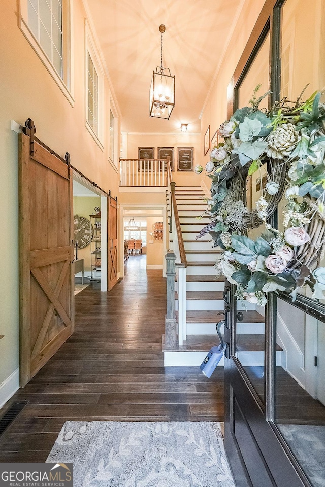 150 Shady Grove Ln, Alpharetta, GA 30009 - entrance foyer with a barn door, dark wood-type flooring, a chandelier, stairway, and baseboards