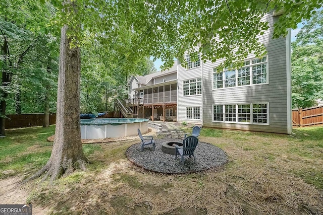 150 Shady Grove Ln, Alpharetta, GA 30009 - rear view of house featuring an outdoor fire pit, a covered pool, a deck, and a sunroom