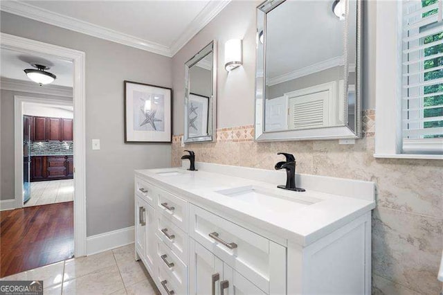 bathroom with double vanity, tasteful backsplash, ornamental molding, and a sink
