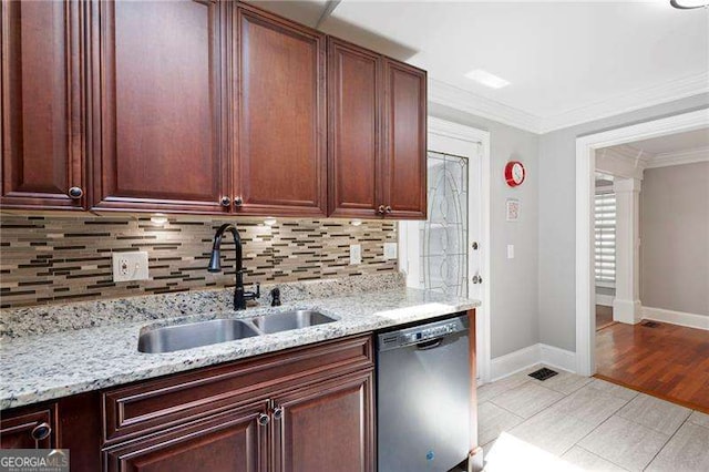 kitchen featuring a sink, tasteful backsplash, light stone counters, stainless steel dishwasher, and baseboards