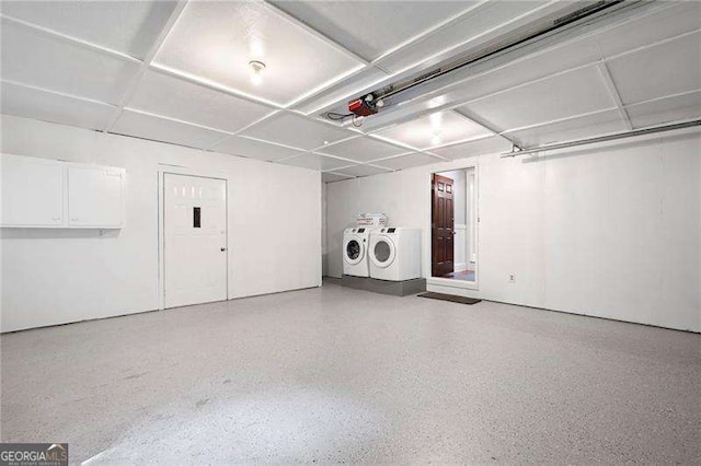garage with independent washer and dryer and a garage door opener