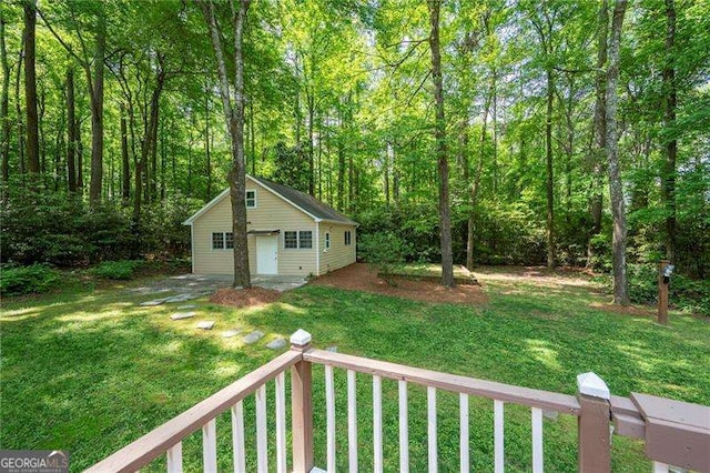 view of yard with a wooded view, an outdoor structure, and a garage