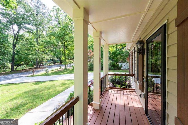 deck featuring a porch and a lawn