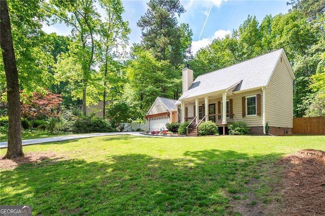 view of front of property with a porch, fence, a garage, a front lawn, and a chimney