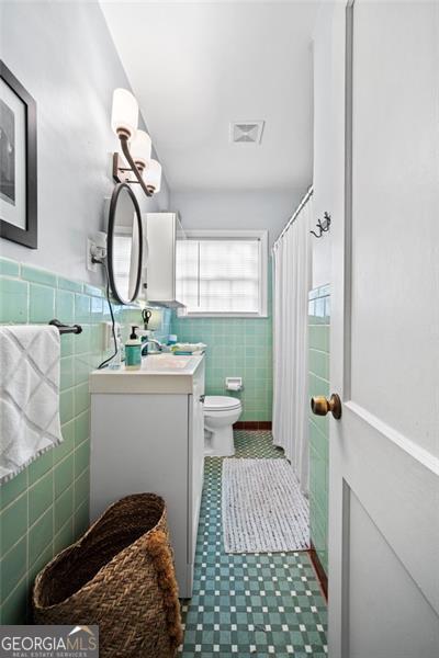 1941 Headland Dr, East Point, GA 30344 - bathroom with visible vents, tile walls, wainscoting, vanity, and toilet