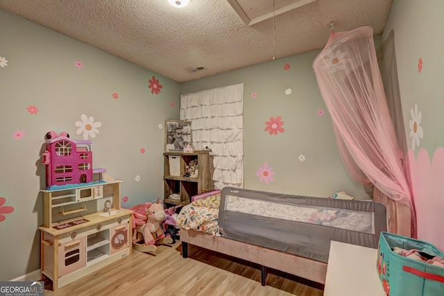 172 Evergreen Dr, Jackson, GA 30233 - bedroom featuring a textured ceiling, visible vents, wood finished floors, and attic access