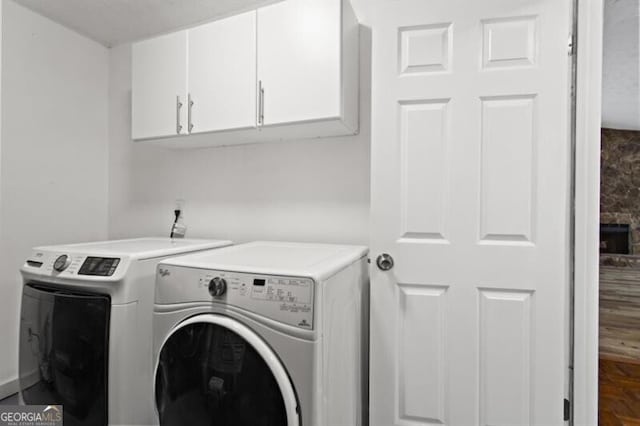 clothes washing area with cabinet space and washer and dryer