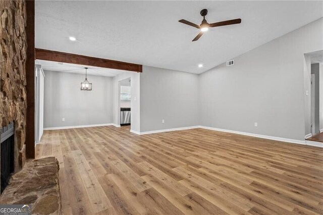 unfurnished living room with ceiling fan, a stone fireplace, light wood-type flooring, baseboards, and recessed lighting