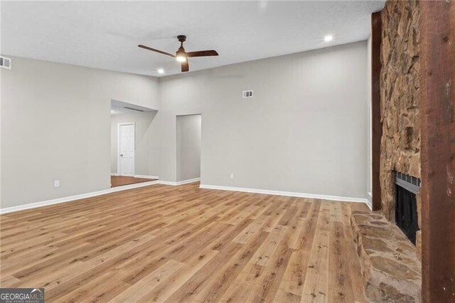 unfurnished living room with a ceiling fan, light wood finished floors, baseboards, a fireplace, and recessed lighting