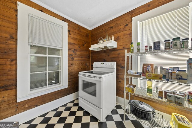 kitchen with white electric range, tile patterned floors, wooden walls, ornamental molding, and under cabinet range hood