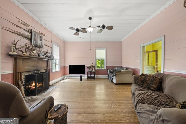 living area featuring wood walls, hardwood / wood-style flooring, and ornamental molding