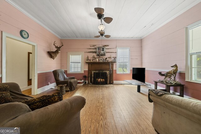 living room with crown molding, wood finished floors, and wooden walls