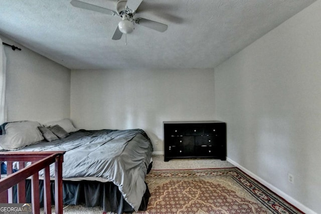 bedroom featuring carpet floors, a ceiling fan, baseboards, and a textured ceiling