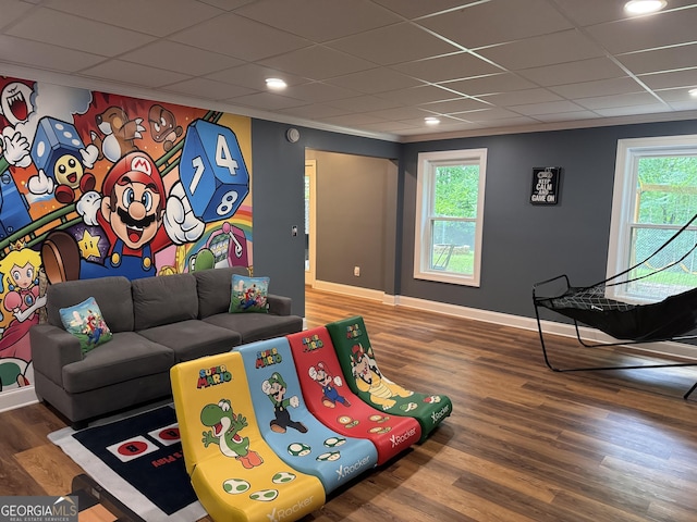 playroom with baseboards, a drop ceiling, and wood finished floors