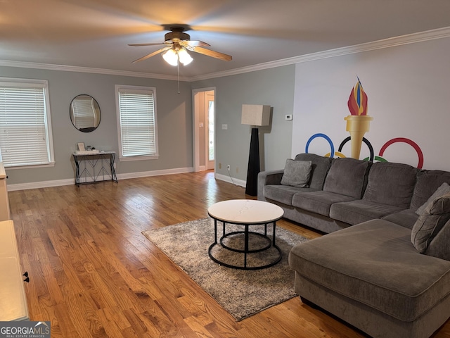 living area with crown molding, ceiling fan, wood finished floors, and a wealth of natural light