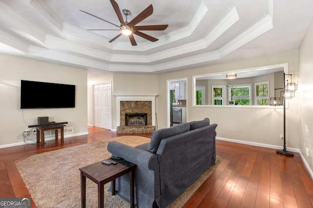 588 Peachtree Dr SE, White, GA 30184 - living area featuring a tray ceiling, crown molding, ceiling fan, hardwood / wood-style floors, and a stone fireplace