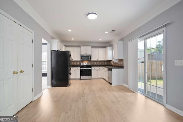 5244 Carrington Park Dr, Powder Springs, GA 30127 - kitchen with crown molding, decorative backsplash, white cabinets, light wood-style flooring, and appliances with stainless steel finishes