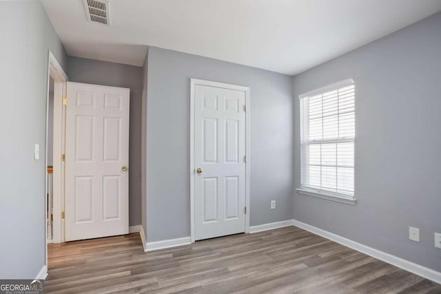 5244 Carrington Park Dr, Powder Springs, GA 30127 - unfurnished bedroom featuring baseboards, wood finished floors, and visible vents