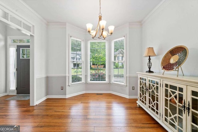 1126 Gate Post Ct, Powder Springs, GA 30127 - unfurnished dining area with plenty of natural light, ornamental molding, a chandelier, and hardwood / wood-style floors