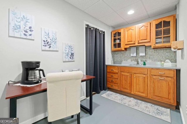 1126 Gate Post Ct, Powder Springs, GA 30127 - kitchen with backsplash, finished concrete floors, light countertops, a sink, and glass insert cabinets