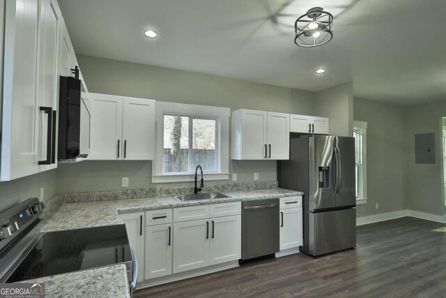 kitchen featuring dark wood-style flooring, appliances with stainless steel finishes, a sink, recessed lighting, and white cabinetry