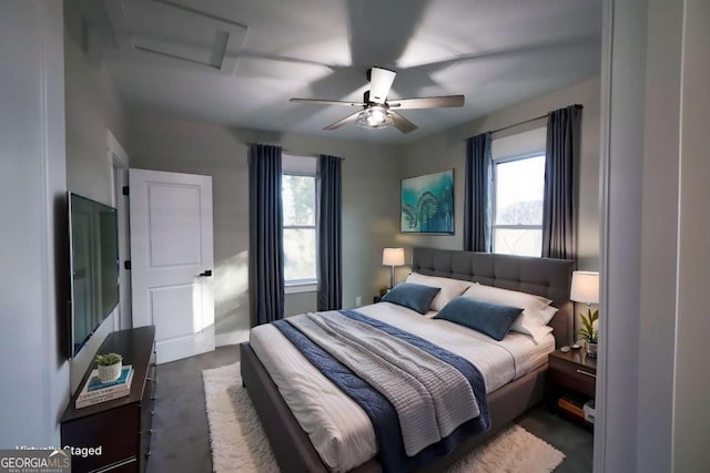 bedroom with attic access, ceiling fan, and multiple windows