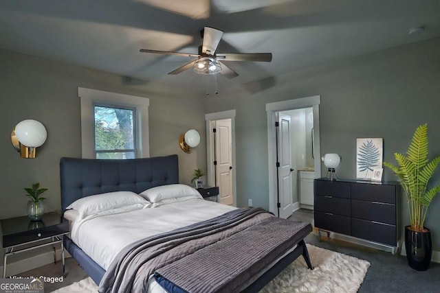 bedroom with connected bathroom, a ceiling fan, baseboards, and dark carpet