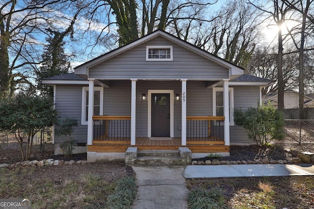 bungalow-style home with fence and covered porch
