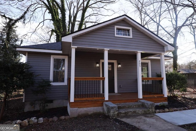 bungalow-style home with covered porch and a shingled roof