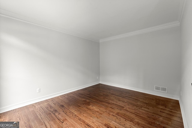 spare room featuring visible vents, dark wood finished floors, crown molding, and baseboards