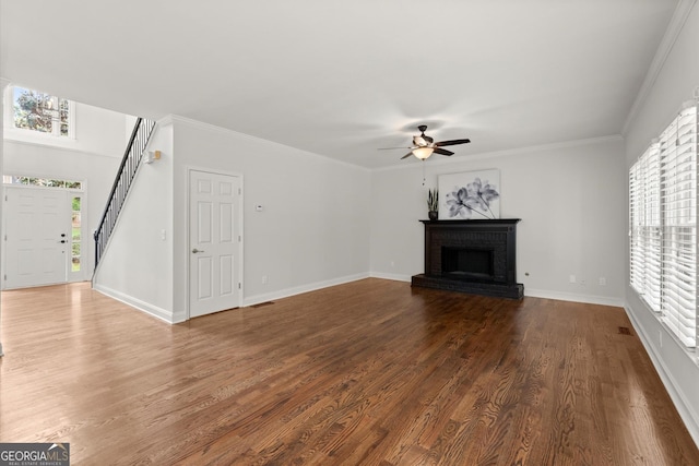 unfurnished living room featuring a brick fireplace, ceiling fan, dark wood finished floors, and baseboards
