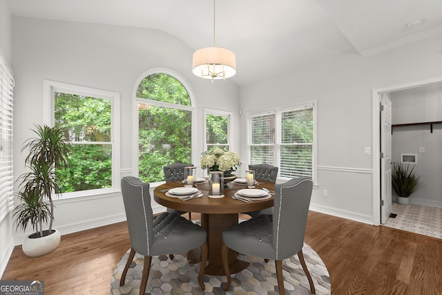 dining area with baseboards, vaulted ceiling, and wood finished floors