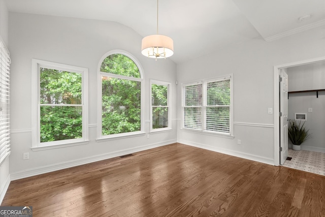 unfurnished dining area featuring visible vents, wood finished floors, vaulted ceiling, and a healthy amount of sunlight