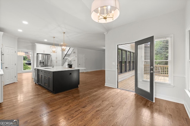 kitchen with light countertops, a kitchen island with sink, appliances with stainless steel finishes, and plenty of natural light