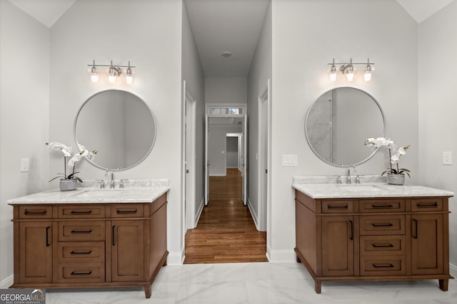 bathroom with a sink, marble finish floor, and two vanities
