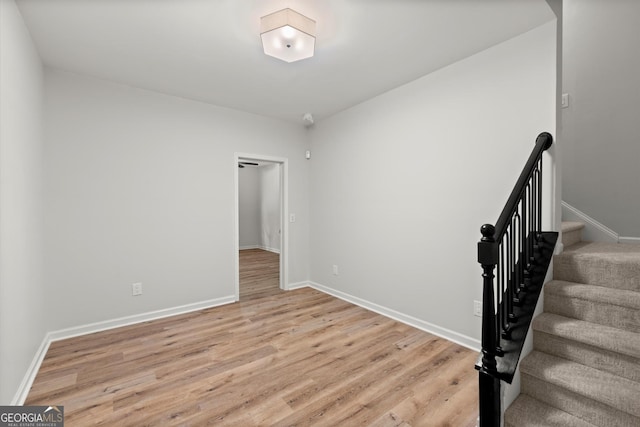 stairway featuring wood finished floors and baseboards